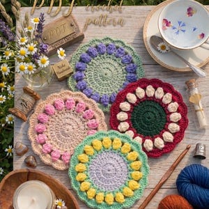 May include: A collection of five handmade crochet coasters in various colors, including pink, green, and red, arranged on a wooden surface. The image also features a teacup, yarn, and a crochet hook. Text on the image reads "PDF crochet pattern".
