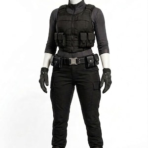 Könnte beinhalten: Ein schwarzes taktisches Outfit bestehend aus einem langärmeligen Oberteil, einer Reißverschlussweste mit mehreren Vordertaschen, einem Gürtel mit Taschen, einer Cargohose und schwarzen Stiefeln. Das Set enthält schwarze Handschuhe auf einer Puppe.