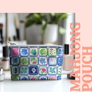 Könnte beinhalten: Ein weißes Etui mit Reißverschluss und einem farbenfrohen Blumenfliesenmuster. Das Design zeigt blaue, grüne und rosa Blumen und Blätter auf weißem Hintergrund. Der Text "MAHJONG POUCH" ist vertikal in Pfirsich gedruckt.