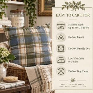 Blue and olive tartan pillow cover displayed in a cozy cottage laundry setting beside care instructions for machine washing, no bleach, no tumble drying, low heat ironing or steaming, and no dry cleaning.