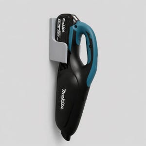 Könnte beinhalten: Ein schwarzer und türkisblauer Makita Akku-Staubsauger mit einer grauen Wandhalterung. Der Staubsauger hat einen türkisfarbenen Griff und das Makita-Logo ist sichtbar. Der Akku ist mit 18V und 5,0 Ah beschriftet.