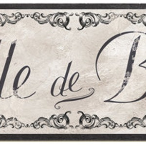 May include: A black and white sign with a decorative border and the text "Salle de Bain" in a cursive font.