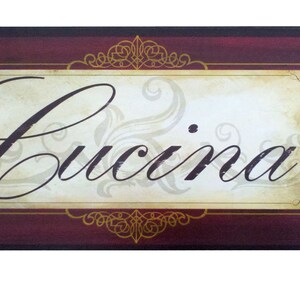 May include: A burgundy wooden sign with gold accents and the word "Cucina" written in a decorative script font.