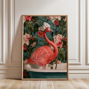 Può includere: Una stampa artistica da parete incorniciata raffigurante un vivace fenicottero rosa che indossa una cuffia da doccia bianca, in piedi all'interno di una vasca da bagno bianca. Lo sfondo mostra un fitto motivo di foglie verdi lussureggianti e grandi fiori di ibisco rossi e bianchi.