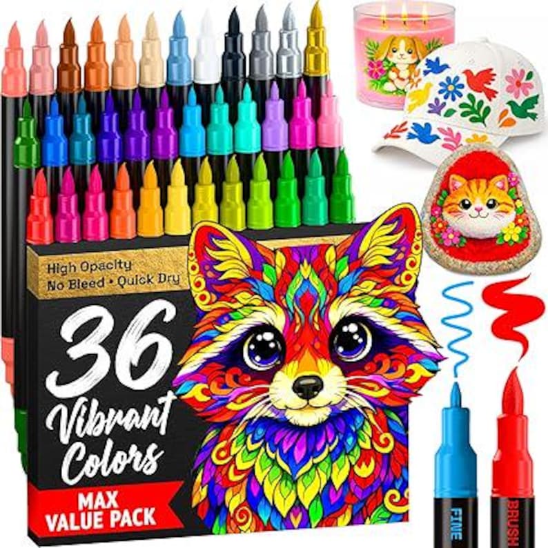 May include: A set of 36 vibrant colour markers in a black box featuring a colourful raccoon illustration. The box displays the text 36 Vibrant Colours, High Opacity, No Bleed, Quick Dry, and Max Value Pack. Includes a white cap with floral patterns, a painted rock with a cat face, and a pink candle.