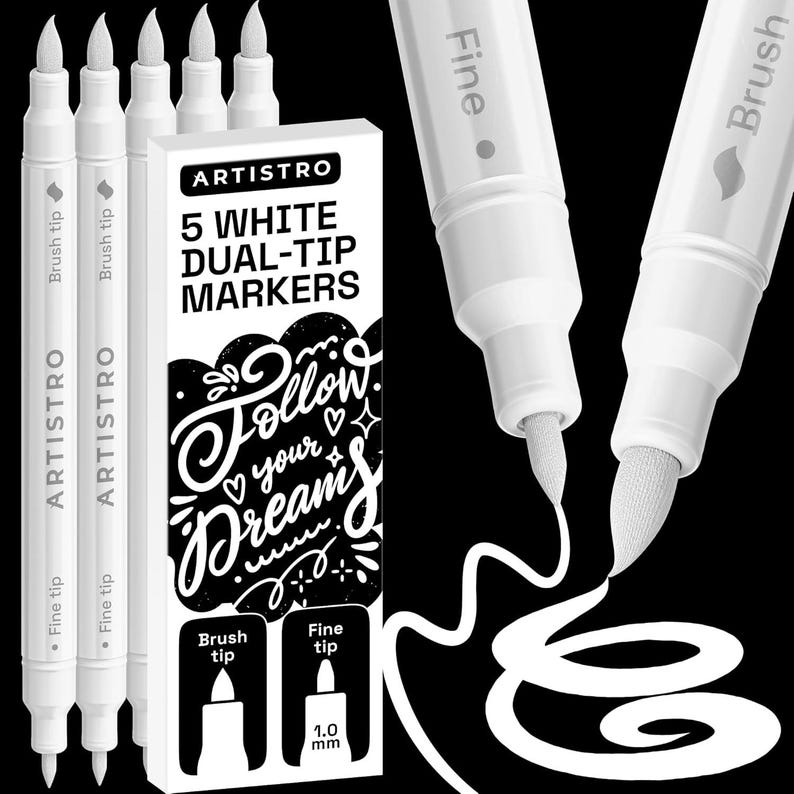 May include: Five white dual-tip markers by Artistro with a rectangular box featuring the text "5 WHITE DUAL-TIP MARKERS" and "Follow your dreams". The markers have a fine tip and a brush tip, with one marker showing a 1.0 mm fine tip label.