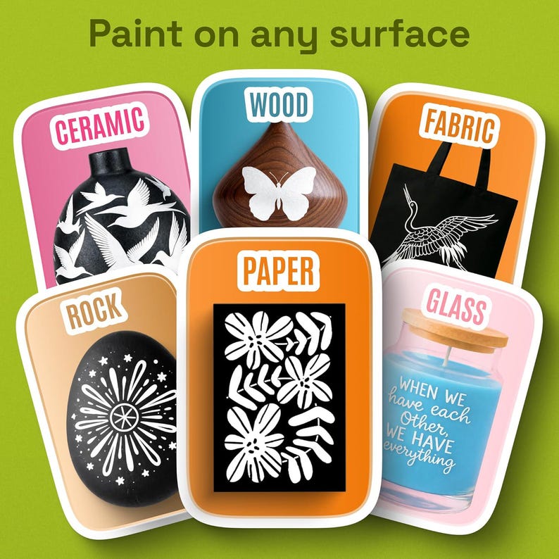May include: A set of six rectangular cards labeled Paint on any surface, featuring examples of painted items: a black ceramic vase with white birds, a wood shape with a butterfly, a black fabric tote, a black rock, paper with flowers, and a blue glass candle.