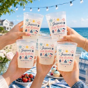 Può includere: Cinque bicchieri di plastica trasparente pieni di un liquido giallo vengono alzati per un brindisi. Ogni bicchiere è stampato con un design a tema spiaggia, tra cui una palma, un sole e il testo "Jessica's 30th Birthday" e "Charleston, SC".