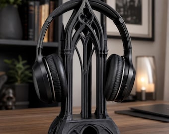 May include: A black headphone stand featuring an intricate architectural design inspired by gothic cathedral arches, with a pointed top, vertical columns, and a wide base, supporting a pair of black over-ear headphones.