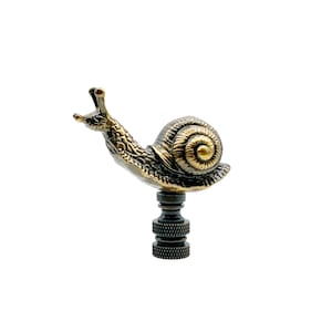 May include: A bronze snail finial with a gold shell, used for a lamp or curtain rod.