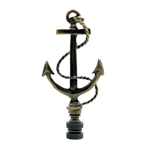 May include: A gold-toned metal lamp finial shaped like an anchor with a rope wrapped around it.