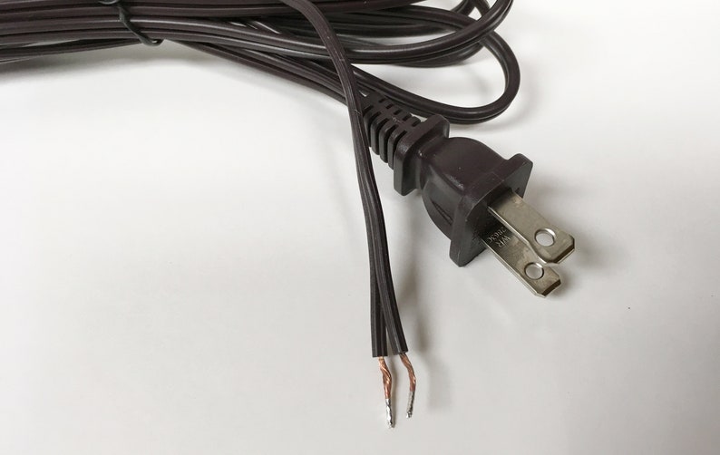 May include: A brown electrical cord with a two-prong plug and exposed wires.