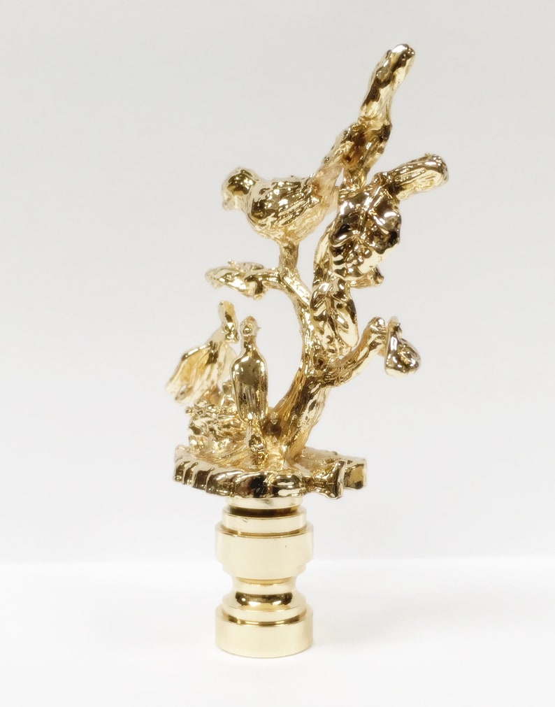 May include: Gold lamp finial with a tree branch design and three birds perched on the branches.