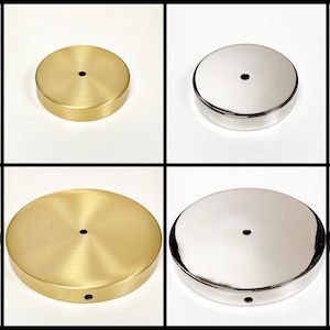 May include: A set of round metal lamp bases in two finishes: gold and silver. The bases are stacked in a pyramid shape, with the largest base at the bottom and the smallest base at the top. The bases have a smooth, polished finish.