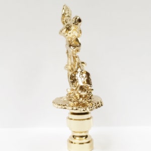 May include: Gold-toned metal lamp finial with a detailed design of birds perched on a branch. The finial has a round base.