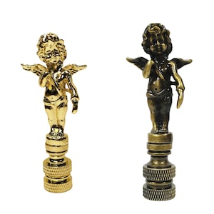 May include: Two cherub finials, one gold and one antique brass, with wings and a base. These decorative finials are perfect for adding a touch of elegance to any lamp or curtain.