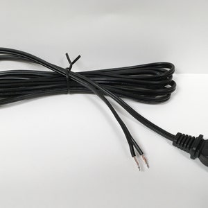 May include: A black electrical extension cord with a standard two-prong plug and exposed wire ends.