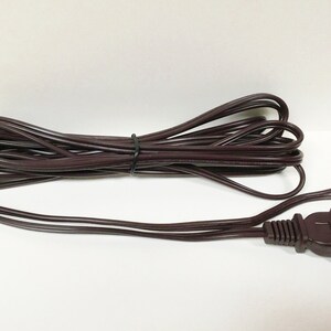 May include: A brown electrical extension cord with a two-prong plug.