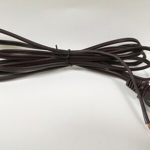 May include: A brown electrical extension cord with a standard US plug. The cord is coiled and ready to use.