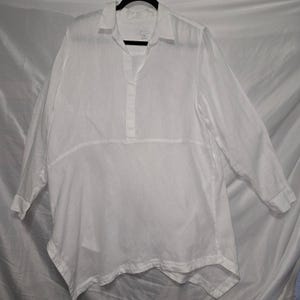 May include: A long-sleeved white tunic shirt featuring a classic collar, a partial button-down placket, and a horizontal seam across the midsection. The garment has a relaxed, flowing silhouette with an asymmetrical hemline and long sleeves.