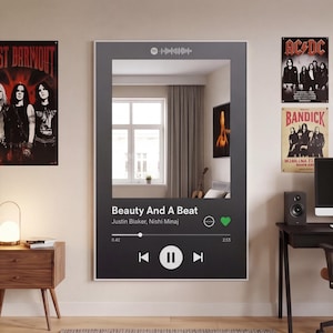 May include: A large, rectangular mirror with a black frame. The mirror's design mimics a music player interface, displaying song information for "Beauty And A Beat" by Justin Blaker and Nishi Minaj. The room's interior is reflected in the mirror.