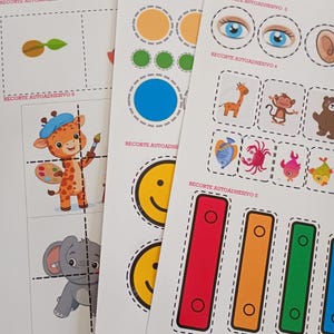 May include: Sheets of printed stickers with various designs. Includes circles, eyes, a giraffe, a monkey, a bear, fish, crabs, and colorful rectangles. Text on the sheets reads "RECORTE AUTOADHESIVO" and numbers 1, 3, 4, 5, and 8.