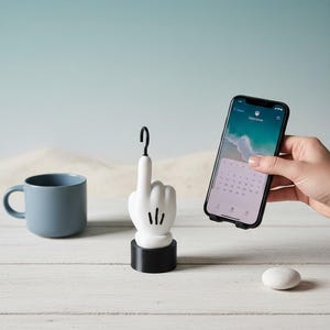 May include: A white and black decorative finger-shaped object with a question mark on top. A blue mug and a smartphone are also on the white surface. The smartphone displays a calendar.