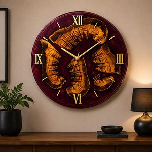 Puede incluir: Un reloj de pared redondo con un fondo de resina color burdeos profundo y rodajas de madera natural incrustadas. La esfera muestra números romanos dorados en las posiciones de las doce, tres, seis y nueve, con manecillas doradas finas.