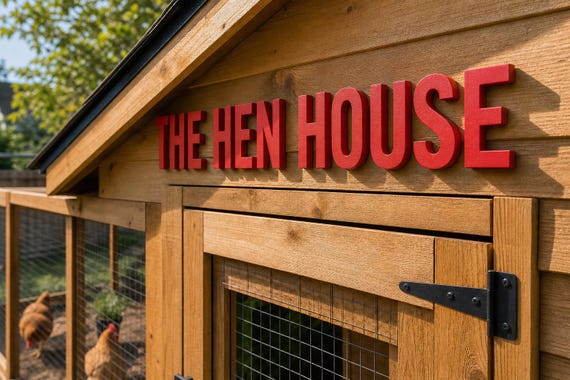 Pawprint Place Raised Letter Set spelling The Hen House in red on a chicken coop from an angled view.