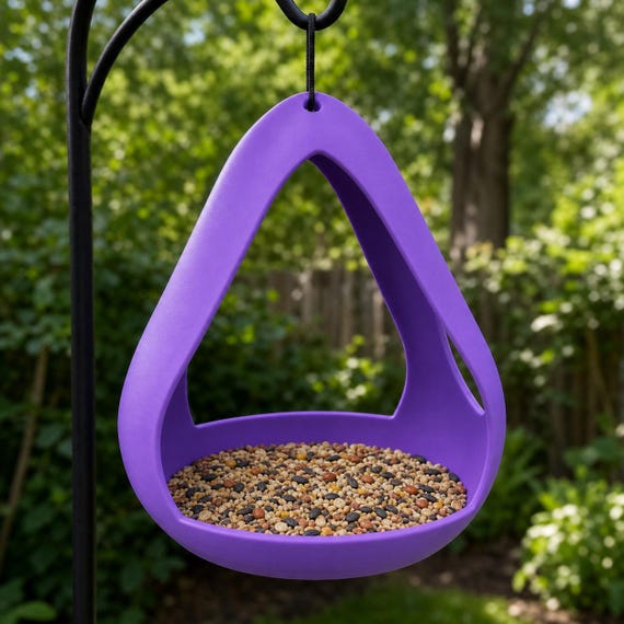 Low angle of a Purple AeroNest open frame bird feeder hanging outdoors