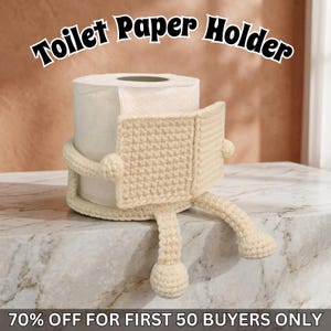 May include: A cream-colored, crocheted toilet paper holder shaped like a character, hugging a roll of white toilet paper. The text "Toilet Paper Holder" is arched above the holder.