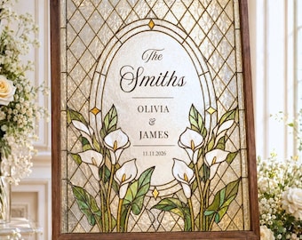 Può includere: Un cartello rettangolare in vetro colorato con cornice in legno scuro su un cavalletto. Il vetro presenta un motivo a griglia a rombi, un arco ovale centrale e illustrazioni di calle bianche. Testo: The Smiths, Olivia & James, 11.11.2026.
