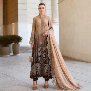 Könnte beinhalten: Ein langärmeliges Tunikakleid mit einem Farbverlauf von hellem Beige oben bis zu Dunkelbraun am Saum, verziert mit aufwendigen Stickereien, einem passenden transparenten Schal mit Spitzenbesatz und einer kleinen metallischen Handtasche.