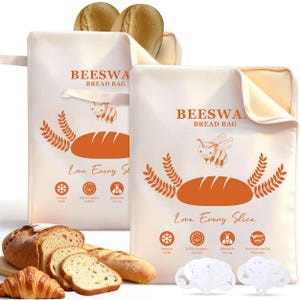 May include: Two off-white rectangular beeswax bread bags featuring orange graphics of a bee, wheat stalks, and a loaf of bread. The text reads BEESWAX BREAD BAG and Love Every Slice, with icons for freezer safe, 100% organic cotton, and beeswax lining.