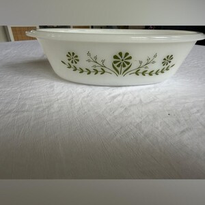 Puede incluir: Bol para servir ovalado blanco con un diseño floral verde. El cuenco tiene una forma simple y elegante con un borde ligeramente ensanchado. El patrón floral verde es simétrico y añade un toque de encanto vintage.