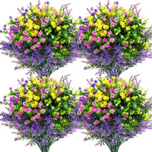 May include: Four bundles of artificial flowers with a mix of colors. The flowers include yellow, pink, and purple blooms, with green foliage. The bundles are arranged closely together, creating a full and vibrant display. Perfect for home decor or crafting.