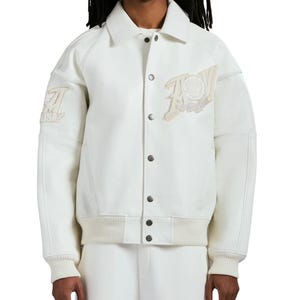 May include: An off-white varsity jacket featuring a classic collar, a front button closure with metallic buttons, and ribbed cuffs and hem. The jacket includes textured panels on the sleeves and embroidered patches on the chest and right sleeve.