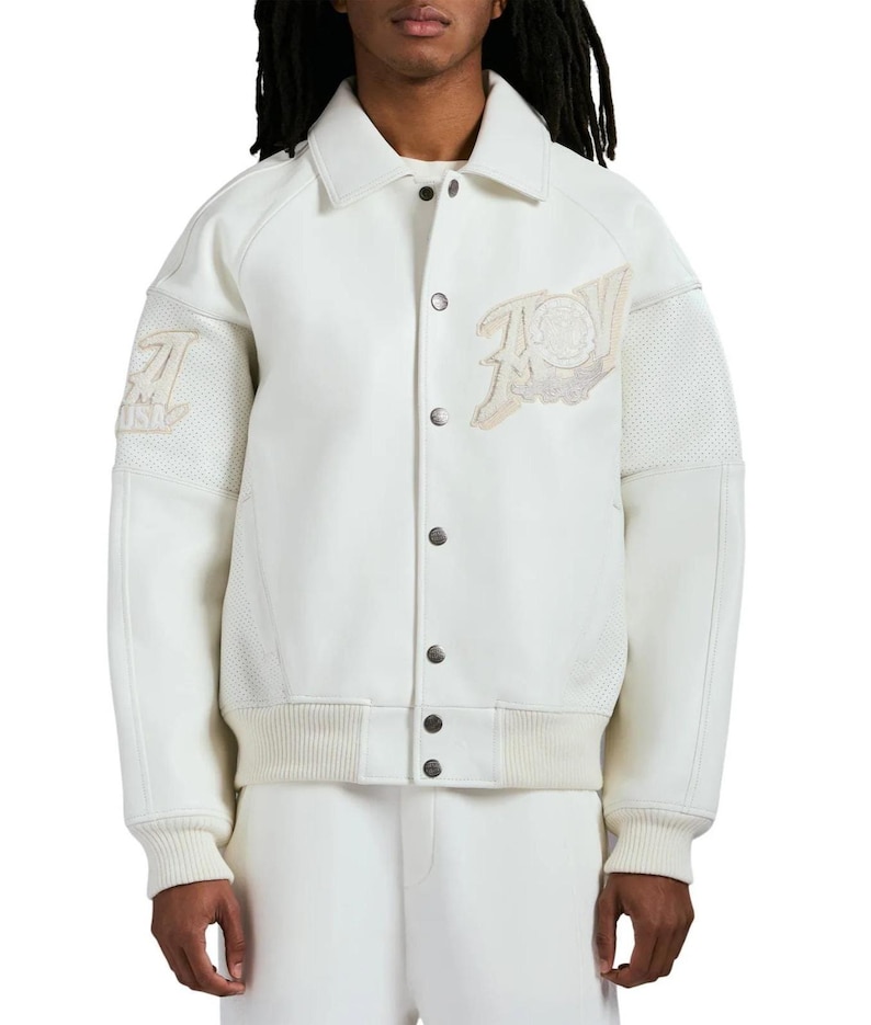 May include: An off-white varsity jacket featuring a classic collar, a front button closure with metallic buttons, and ribbed cuffs and hem. The jacket includes textured panels on the sleeves and embroidered patches on the chest and right sleeve.
