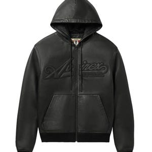 K&ouml;nnte beinhalten: Eine schwarze Lederjacke mit Kapuze, durchgehendem Frontrei&szlig;verschluss, langen &Auml;rmeln mit gerippten B&uuml;ndchen und einem gerippten Saum. Auf der Brust befindet sich der gepr&auml;gte Schriftzug "Avirex". Die Jacke verf&uuml;gt &uuml;ber eine K&auml;ngurutasche.