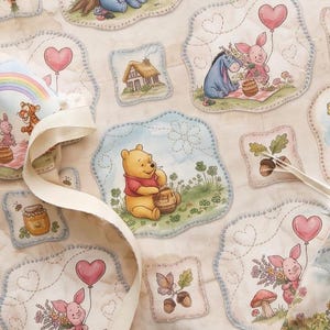 May include: A quilted fabric featuring a repeating pattern of Winnie the Pooh characters including Eeyore, Piglet, and Pooh Bear. The illustrations are set within scalloped-edge patches on a cream background, accented by hearts, trees, and honey pots.