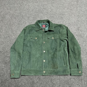 Puede incluir: Chaqueta de ante verde con cierre de botones, dos bolsillos en el pecho y dos bolsillos laterales. La chaqueta tiene un cuello clásico y puños abotonados. La chaqueta es de color verde medio liso.