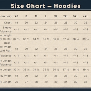 Puede incluir: Una tabla de tallas beige para sudaderas con capucha con texto oscuro. Enumera las medidas en pulgadas para las tallas de la XS a la 5XL, incluyendo el ancho del pecho, largo de manga desde el centro de la espalda, largo y ancho corporal.
