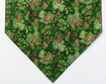 Pine Cones Table Runner, Red Berries, Green Holly and Pine Boughs are scattered on a rich green background, 36"