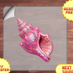 May include: A pink sequined seashell design, ready to press. The seashell is a vibrant pink with a detailed texture. The image includes the text "READY TO PRESS!" and "DTF TRANSFER".