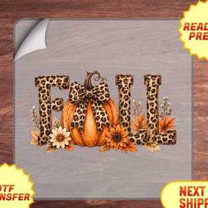 May include: A DTF transfer sheet featuring the word FALL in a leopard print pattern. The letter A is replaced by an orange pumpkin with a leopard print bow. The design includes sunflowers and autumn leaves surrounding the letters.