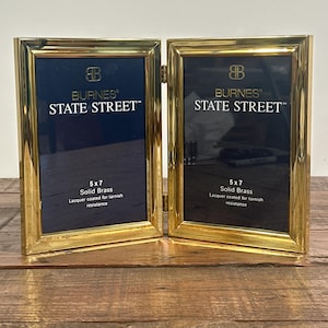 May include: A hinged, double-sided photo frame made of polished gold-colored brass. Each frame holds a 5x7 inch photo and features the text "BURNES STATE STREET". The frames are lacquer coated for tarnish resistance.