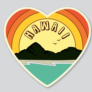 May include: A heart-shaped sticker with a retro sunset design. The sticker features a yellow sun with orange and red stripes, a mountain range, a beach, and the word "HAWAII" in a vintage font.