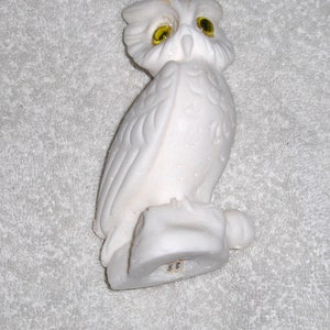 Puede incluir: Figurita de b&uacute;ho de cer&aacute;mica blanca con ojos de vidrio amarillo. El b&uacute;ho est&aacute; posado sobre una base y tiene plumas detalladas. La figurita est&aacute; hecha en Italia.
