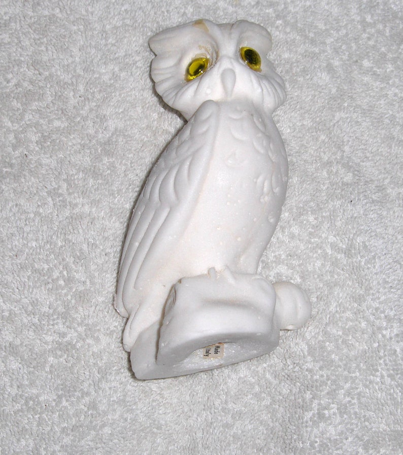 Puede incluir: Figurita de b&uacute;ho de cer&aacute;mica blanca con ojos de vidrio amarillo. El b&uacute;ho est&aacute; posado sobre una base y tiene plumas detalladas. La figurita est&aacute; hecha en Italia.