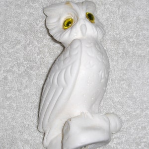 Puede incluir: Figurita de b&uacute;ho de cer&aacute;mica blanca con ojos de vidrio amarillo. El b&uacute;ho est&aacute; posado sobre una base y tiene plumas detalladas.